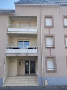 un immeuble d'appartements avec un balcon sur le côté dans l'établissement L'Aéroplage, Appartement Standing Rénové Vacances 40mètres plage, à Berck-sur-Mer