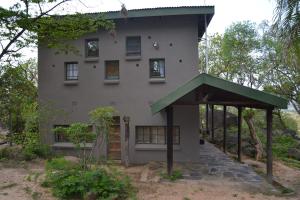 a house with a green awning in front of it at Leopard Tree Retreat in Nelspruit