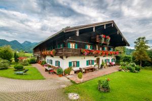 Una casa grande con flores al costado. en Stockinger Hof en Ruhpolding