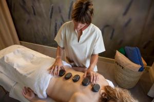 a woman getting a massage from a woman sitting on a bed at Apartaments Vall de Núria in Queralbs