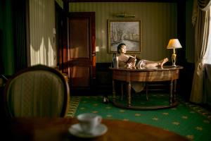 Una donna seduta in una vasca in una stanza di Grand Hotel Emerald a San Pietroburgo