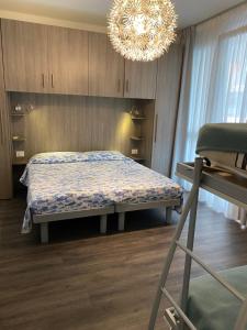 um quarto com uma cama e um lustre em Sole e amore em Lido di Jesolo