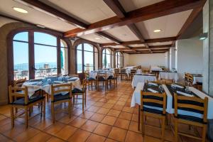 a dining room with tables and chairs and windows at Santuari de la Salut de Sant Feliu de Pallerols in Sant Feliu de Pallerols