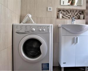 a washing machine in a bathroom next to a sink at Studio Emi in Pomorie