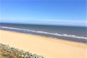 una playa con una fila de rocas y el océano en Exceptional Chalet near to Beach, Broads & Gt Yarmouth en Great Yarmouth