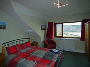 a bedroom with a bed and a large window at Bryn Melyn Apartments in Barmouth
