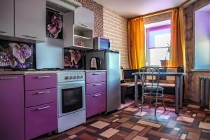 チェレポヴェツにあるApartment in a New Buildingの紫色のキャビネットとテーブル付きのキッチン