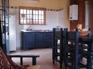 cocina con armarios azules, mesa y sillas en Solares de la Laguna en Santa Fe
