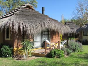 domek z dachem krytym strzechą i patio w obiekcie Solares de la Laguna w mieście Santa Fe
