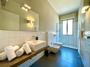 a white bathroom with a sink and a toilet at Maison A in La Spezia