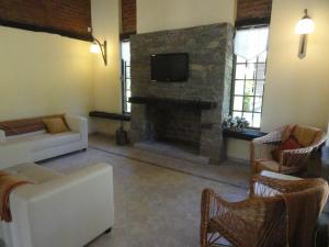 sala de estar con sofá y chimenea en Solares de la Laguna en Santa Fe
