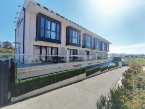 un edificio con ventanas laterales en Apartamentos Playa De Covachos, en Soto de la Marina