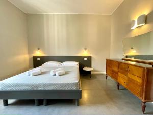 a bedroom with a bed with a dresser and a mirror at Maison A in La Spezia