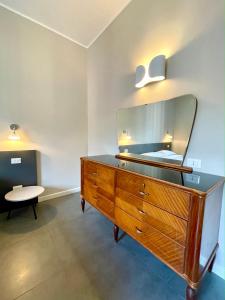 eine Kommode mit einem Spiegel darüber in einem Zimmer in der Unterkunft Maison A in La Spezia