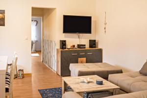 a living room with a couch and a flat screen tv at Fewo-llojan in Wiesmoor