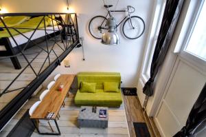 een woonkamer met een groene bank en een fiets aan de muur bij Altitude Loft in Sarajevo