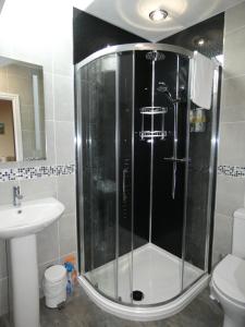a shower in a bathroom with a sink and a toilet at Bryn Melyn Apartments in Barmouth +37 photos