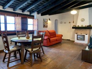 a living room with a table and a couch at Casa La Corrala in Chinchón