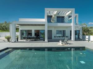 a villa with a swimming pool in front of a house at ELYSIAN VILLA in Amoudi