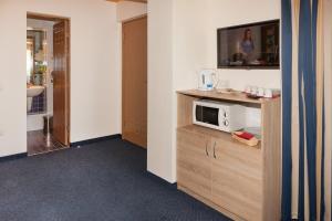 una stanza con una TV e un microonde su un mobile di Tauras Center Hotel a Palanga