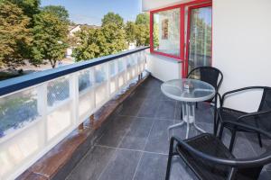 un balcone con sedie, un tavolo e una finestra di Tauras Center Hotel a Palanga