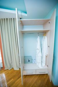 Zimmer mit einem Schrank mit weißer Kleidung und einem Fenster in der Unterkunft Home Sweet Home in Chişinău