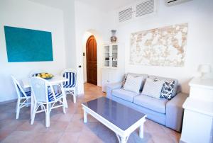 a living room with a couch and a table and chairs at Villa Titina - Sunset Apartments in Ischia