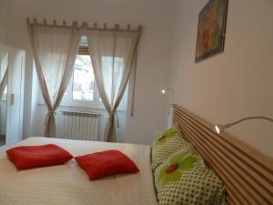 um quarto com uma cama com duas almofadas vermelhas em Stesi Vacanze em Roma