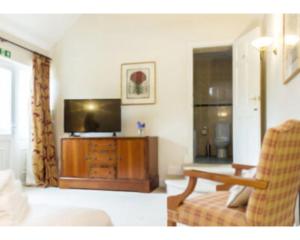 uma sala de estar com uma televisão e um sofá em The Bull Inn em Bourne
