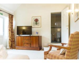 a living room with a television and a couch at The Bull Inn in Bourne