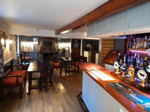 a bar with tables and chairs in a restaurant at The Bull Inn in Bourne