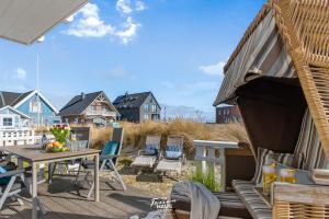 eine Terrasse mit einem Tisch und Stühlen auf einer Terrasse in der Unterkunft Strandblick in Olpenitz