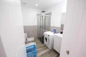 ein Badezimmer mit Toilette, Waschbecken und Waschmaschine in der Unterkunft flower apartment in Playa de las Americas