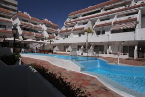 ein Pool vor zwei großen Gebäuden in der Unterkunft flower apartment in Playa de las Americas