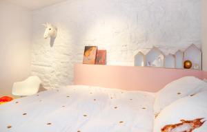 1 dormitorio con cama blanca y cabecero de unicornio en Le Moulin de Bosson - Ourasi, en Ferrières