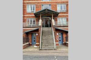 a brick building with stairs in front of it at City Central Apartment in Coventry