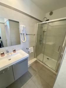a bathroom with a shower, sink, and toilet at Hotel Belvedere in Calvi