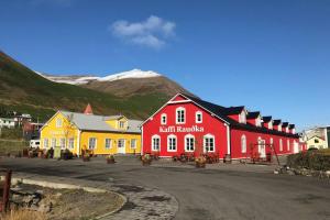 un groupe de bâtiments avec des montagnes en arrière-plan dans l'établissement House with a warm soul in North Iceland, à Siglufjörður