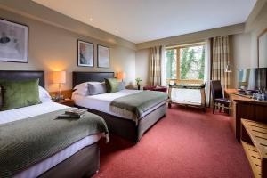 una camera d'albergo con due letti e una scrivania di Manor West Hotel & Leisure Club a Tralee