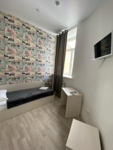 een kamer met een bed en een muur bedekt met posters bij Art-Hotel Centralnyi in Kostroma