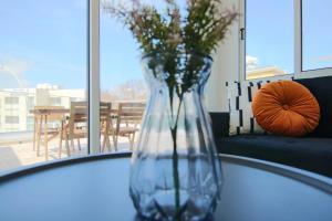 un jarrón de cristal con flores sentado en una mesa en Phaedrus Living: Seaside Modern Flat Lighthouse 63, en Pafos