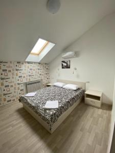 een slaapkamer met een bed en een dakraam bij Art-Hotel Centralnyi in Kostroma
