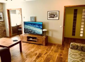 sala de estar con TV de pantalla plana en un soporte en Kohtu Apartment Unique, en Kuressaare