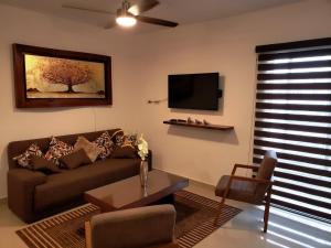 - un salon avec un canapé et une télévision dans l'établissement Casa con Alberca a solo 5 minutos de Playas de Nuevo Vallarta RBL33, à Nuevo Vallarta