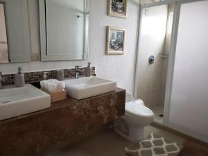 La salle de bains est pourvue d'un lavabo, de toilettes et d'un miroir. dans l'établissement Casa con Alberca a solo 5 minutos de Playas de Nuevo Vallarta RBL33, à Nuevo Vallarta