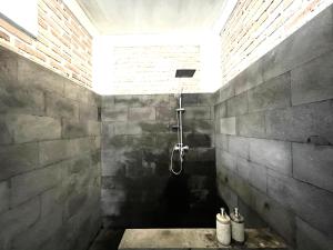 a bathroom with a shower in a brick wall at The Breezy Volcano in Kintamani
