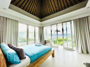 a bedroom with a bed with a view of the ocean at The Breezy Volcano in Kintamani