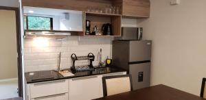 a small kitchen with a refrigerator and a table at Studio amplio y comodo en Equipetrol in Santa Cruz de la Sierra