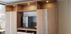 a tv in a wooden cabinet with a television at Studio amplio y comodo en Equipetrol in Santa Cruz de la Sierra