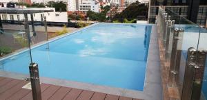 a large blue swimming pool on top of a building at Studio amplio y comodo en Equipetrol in Santa Cruz de la Sierra